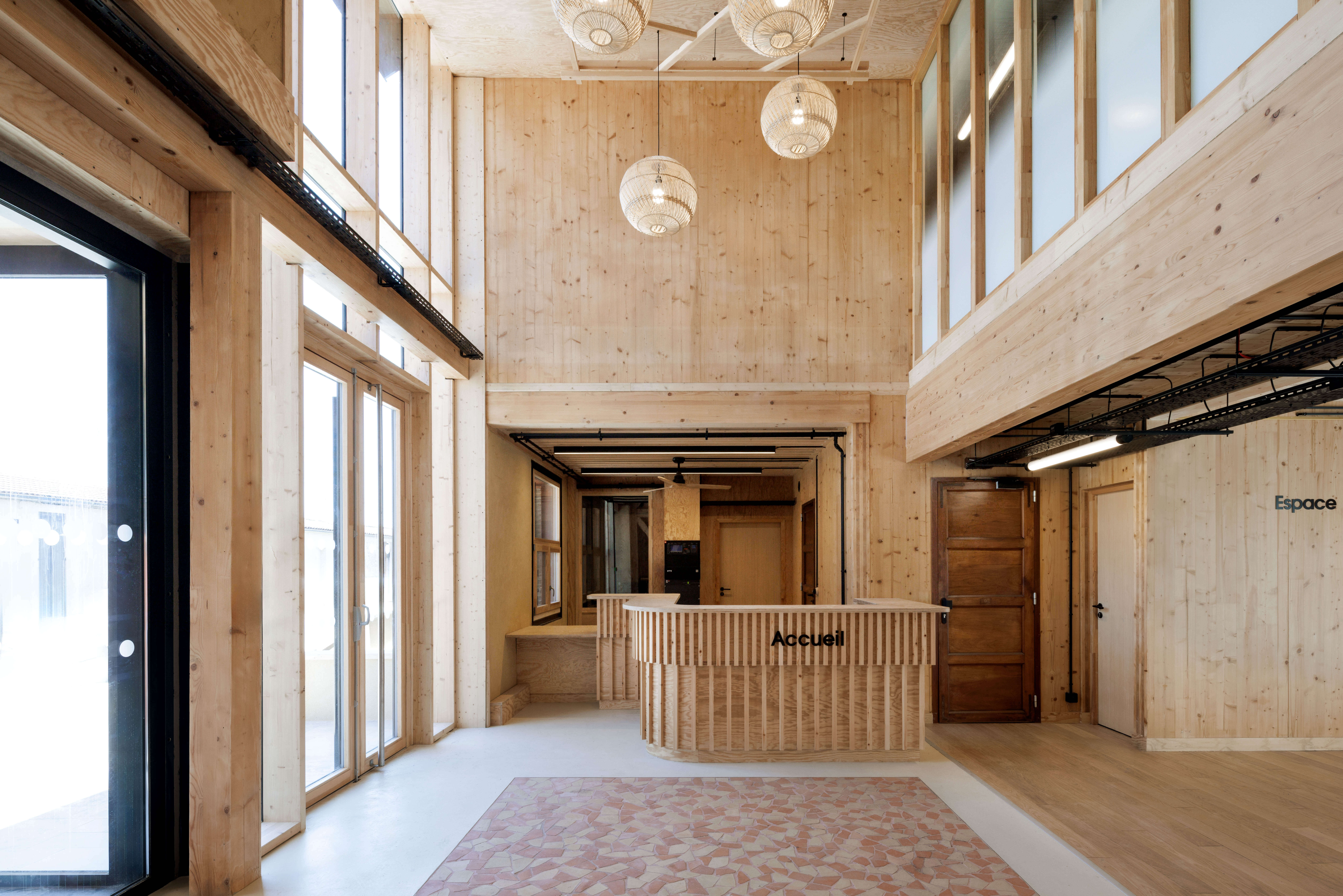Maison des solidarités de Langon — Ambiance chaleureuse des espaces d'accueil intérieurs en bois et terre crue